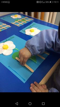 a child is making crafts with popsicle sticks and an egg on a piece of paper