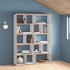 a room with blue walls and white shelves filled with books, vases and other items