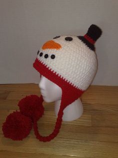 a knitted snowman hat and mitten on a mannequin head