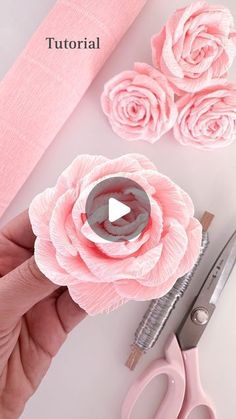 someone is making pink flowers out of fabric