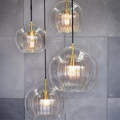 three clear glass pendant lights hanging from a ceiling