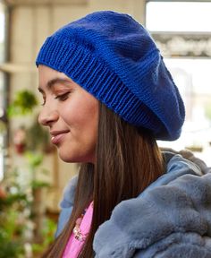 a woman wearing a blue hat looking at her cell phone