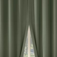 an open window with green curtains in front of it and a white curtain behind the window