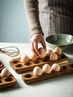 a person is placing eggs in an egg tray on a table with other food items