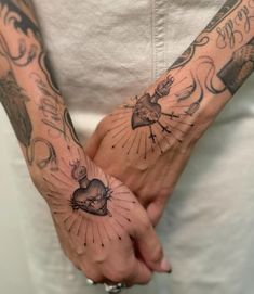 a person holding their hands with tattoos on them