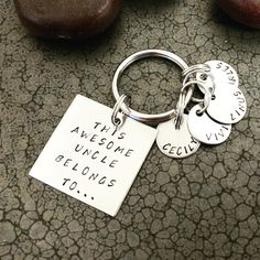 this is an image of two personalized keychains on the ground with rocks in the background