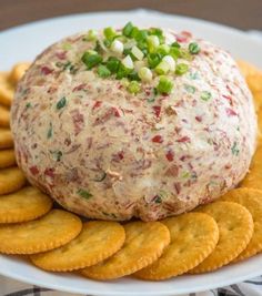 a cheese ball on top of crackers with green onions and celery sprinkles