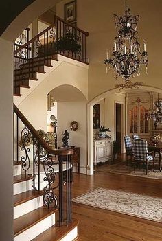 an elegant dining room with chandelier and wooden flooring is seen in this image