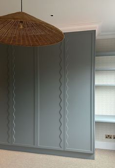 an umbrella hanging from the ceiling in a room with gray cabinets and carpeted flooring