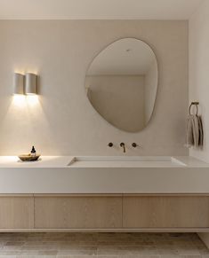 a bathroom with a sink, mirror and lights on the wall next to each other