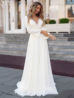 a woman in a white dress standing on steps