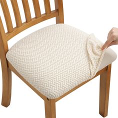 a person cleaning a wooden chair cushion with a microfit pad on the back