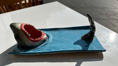 a fake shark's mouth is on a blue plate