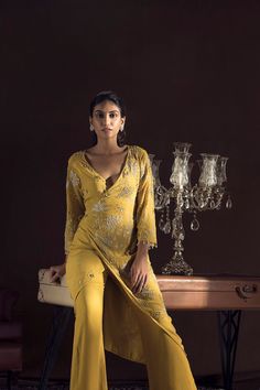 Editor's Note This set features a mustard kimono wrap in crepe. It is embroidered with resham, sequins and pearls, paired with resham embroidered pants. Fabric : Crepe Color : Yellow Care : Dry Clean Only About the Designer ﻿﻿Sanya gulati's designs are inspired by the Indian bridesmaids, pastel easy hues & the seasonal trends, her designs is a mix of modern, contemporary embroideries with traditional silhouettes thus creating our signature asymmetric checks embroideries amalgamated with floral t Frock Suit With Plazo, Plazo Suit Design, Punjabi Suits Online Shopping, Punjabi Suit Design, Punjabi Suits Party Wear, Kurta And Pants, Punjabi Suit Boutique, Indian Bridesmaids, Designer Punjabi Suits