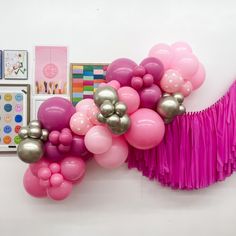 pink and silver balloons are hanging on the wall next to pictures, decorations, and other items