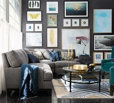 a living room filled with furniture and framed pictures on the wall above it's coffee table