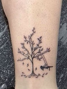 a small tree tattoo on the ankle with an arrow in it's center and leaves