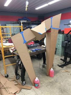 two men are working on cardboard sculptures in a garage