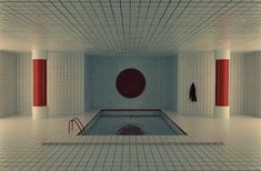 an indoor swimming pool with red and white tiles on the walls, surrounded by tiled flooring