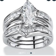 a white gold wedding ring set with an oval cut diamond and baguettes on each band