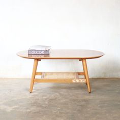 a wooden table with books on it and a white wall in the backround