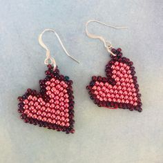 a pair of pink and black beaded heart earrings