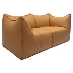 a brown leather chair with two pillows on it's back and the seat folded down