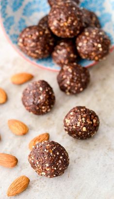 almonds and dark chocolate energy bites on a white table with blue and white patterned bowl