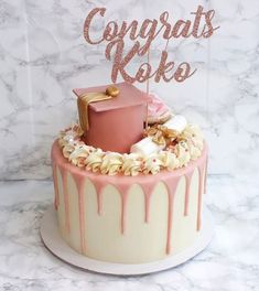 a cake with pink icing and gold decorations