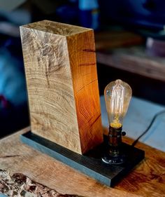 a lamp that is sitting on top of a wooden block with a light bulb in it