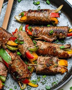 skewered steaks and peppers on a plate with chopsticks