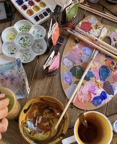 an artist's table with paints, brushes and palettes