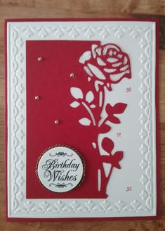 a red and white birthday card with a rose