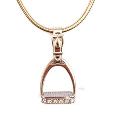 Ashley's signature 14k gold Diamond Medium Stirrup Pendant is designed with a detailed pad in white gold to simulate an actual stirrup. Each stirrup is hand made and hand finished for superior quality by Ashley's with .12ct diamonds, 5/8"W x 1 1/4"L (including strap). Add a chain to make a beautiful Equestrian Horse Ne Equestrian Necklace, Horseshoe Jewelry, Horseshoe Necklace, Equestrian Jewelry, Pendant Diamond, Horse Necklace, Horse Jewelry, Dog Jewelry, Accessories Ideas