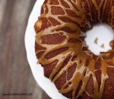 a bundt cake covered in caramel drizzle on a white platter