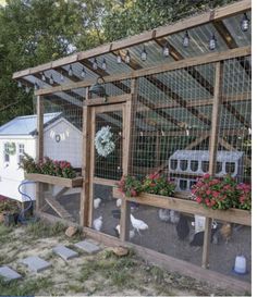 a chicken coop with flowers and chickens in it