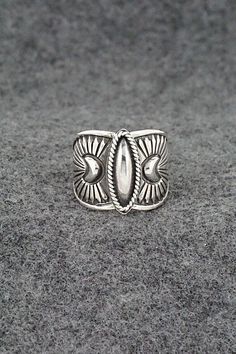 This finely crafted sterling silver ring was made by Navajo silversmith Derrick Gordon. The back is signed Derrick and stamped sterling. Size: 7.5 Length: 5/8" Free shipping on all orders! We ship with USPS and always include tracking. All orders ship within a day of payment. Returns are accepted up to 30 days after you receive your order. Just send us a message. Our shop offers cash back or store credit. The item must be returned in new condition. Sterling Silver Engraved Wide Band Ring, Bohemian Wide Band Jewelry Stamped 925, Southwestern Style Silver Open Ring Jewelry, Southwestern Silver Open Ring Jewelry, Stamped Sterling Silver Wide Band Jewelry, Artisan Engraved Sterling Silver Ring 925, Artisan Sterling Silver Adjustable Engraved Ring, Antique Silver Stamped Sterling Silver Rings, Artisan Sterling Silver Engraved Hallmarked Ring