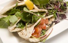 a plate topped with tortillas covered in lettuce and tomatoes