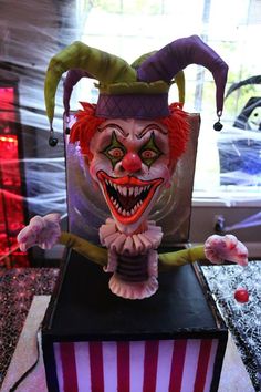 a creepy clown statue sitting on top of a box