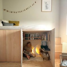 a child is sitting on the floor reading a book in a room with wooden floors