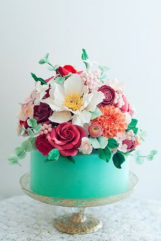 there is a cake decorated with flowers on the top and bottom tier, as well as green frosting