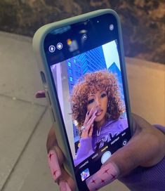 a person holding up a cell phone with an image of a woman on the screen