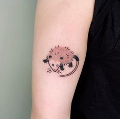 a small hedgehog tattoo on the arm