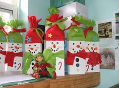 christmas presents are wrapped in green and red paper with snowmen on them, sitting on a mantle