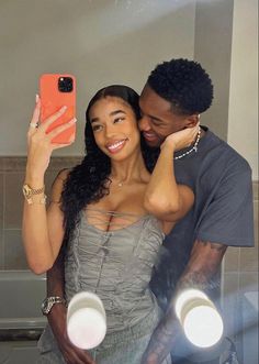 a man and woman taking a selfie in the bathroom