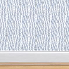 an empty frame with a blue and white herringbone pattern on the wall behind it