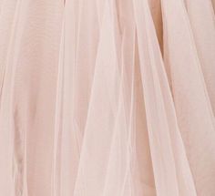 the back of a woman's dress with sheer pink fabric and buttons on it