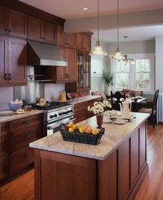 a kitchen filled with lots of wooden cabinets and counter top next to a stove top oven