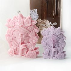 two pink and purple sculptures sitting next to each other