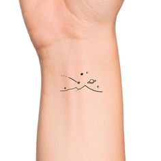 a woman's wrist with a small star tattoo on the left side of her arm